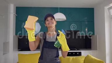 来自<strong>清</strong>洁服务部门的迷人的微笑妇女，手里拿着洗涤剂和抹布，并显示<strong>出清</strong>洁的动作。